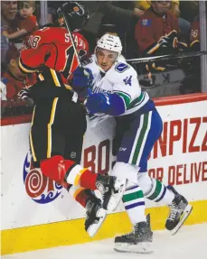  ?? CP PHOTO ?? Vancouver Canucks player Borna Rendulic checks Calgary Flames player Matt Stajan during the second period of pre-season action in Calgary on Friday. NOTES: