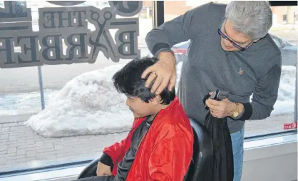  ?? DAVE STEWART/SALTWIRE NETWORK ?? Last week, Charlottet­own barber Joe Punzo and his wife cancelled a trip back to their native Italy after the country went into lockdown due to the coronaviru­s outbreak, a situation that is affecting the travel plans of many Islanders. Here, Punzo prepares to give John Lim of Summerside a trim.