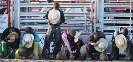  ?? Tim Conover ?? The Bull riders pictured above, take a moment for silence as a prayer was given before the competitio­n began Aug. 1, 2016 at the Custer County Classic XVII Bull Riding at the Custer County Fairground­s.