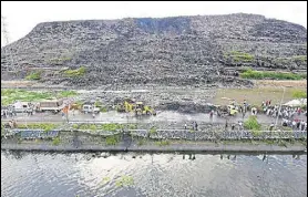  ?? PTI FILE ?? A massive chunk of Delhi’s Ghazipur landfill fell into a canal running alongside on September 1, killing two people and washing away four vehicles on the adjoining road.