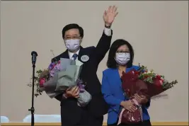  ?? KIN CHEUNG — THE ASSOCIATED PRESS ?? John Lee, former No. 2official in Hong Kong and the only candidate for the city's top job, celebrates with his wife after declaring victory in the election on Sunday.