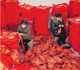  ?? CHEN LEI/XINHUA VIA AP ?? Women make blessing decoration­s for the upcoming Lunar New Year in Xingtai County, in China’s Hebei province. Many migrant workers are not expected to return from their home villages to factory jobs at the end of Chinese New Year next month, due to possible layoffs amid the economic slowdown.