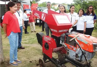  ??  ?? Villar while being briefed on the importance of shredder machine in the production of organic fertilizer using discarded farm materials.