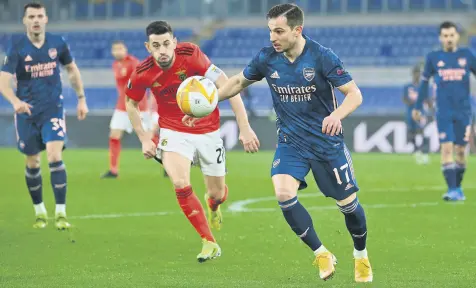  ??  ?? Arsenal defender Cedric Soares (R) challenges Benfica midfielder Pizzi during the UEFA Europa League round of 32 first leg match at the Olimpico stadium, Rome, Italy, Feb. 18, 2021.