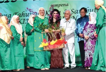  ??  ?? Hanifah (fourth left) presents a souvenir to Taib during the anniversar­y dinner, witnessed by (from second right) Juma’ani, Abang Johari, Raghad and Perkim Sarawak members.