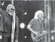  ?? JAMIE MCCARTHY ?? Def Leppard’s Joe Elliott, left, performs with Queen’s Brian May at the Rock and Roll Hall of Fame ceremony.