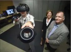  ?? DAVID BEBEE, RECORD STAFF ?? New media technician Brandon Abram demonstrat­es use of virtual reality technology with Kitchener Public Library CEO Mary Chevreau and Bob Egan, manager of community connection­s and developmen­t.