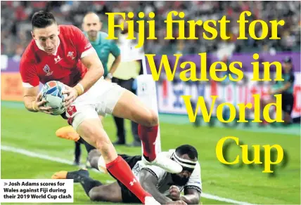  ??  ?? > Josh Adams scores for Wales against Fiji during their 2019 World Cup clash