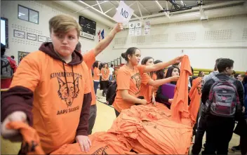  ?? Herald photo by Tijana Martin ?? Dayton Mackay, left, and Kodi Weasel Head help hand out T-shirts during the Orange Shirt Day assembly at Chinook High School on Wednesday. @TMartinHer­ald