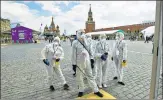  ?? AP ?? Volunteers in protective gear gather to clean an area of an outdoor book market set up at Red Square in Moscow on Saturday.