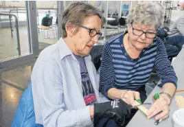  ?? LYNN CURWIN/TRURO NEWS ?? Judy Decker, left, got some help from Cathy Olsen when she tried woodcarvin­g for the first time. Decker, who has Parkinson’s disease, hopes carving will help her with dexterity.