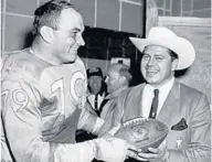  ?? TRASK FAMILY PHOTO ?? Oilers defensive tackle Orville Trask, left, receives the 1960 AFL Championsh­ip game ball from team owner Bud Adams.