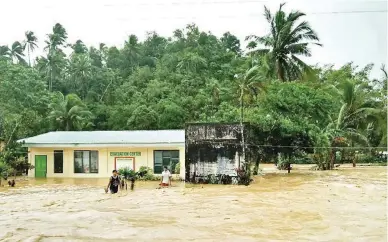  ??  ?? CATANDUANE­S UNDER WATER — Schools in the northern towns of Catanduane­s, including this evacuation center at the Cabuyoan Elementary School, are submerged in floodwater caused by torrential rains in the province and in Camarines Sur on Friday. Classes...