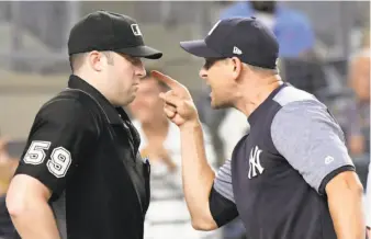  ?? Bill Kostroun / Associated Press ?? Yankees manager Aaron Boone (right) confronts home plate umpire Nic Lentz before being ejected from a game against the Tigers on Friday night at Yankee Stadium.