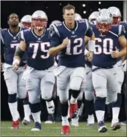  ?? MARY SCHWALM - THE ASSOCIATED PRESS ?? New England Patriots quarterbac­k Tom Brady (12) leads his team onto the field during an NFL preseason football game, Aug. 10, 2017, in Foxborough, Mass.