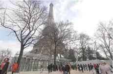  ?? — AFP ?? Tourists and visitors queue to pass the security check at the entrance to the new glass fence around the Eiffel Tower in Paris on Wednesday.