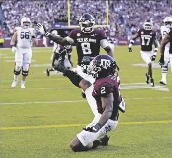  ?? DAVID J. PHILLIP/AP ?? TEXAS A&M DEFENSIVE LINEMAN MICHEAL CLEMONS (2) falls into the end zone for a touchdown after recovering a fumble by Auburn quarterbac­k Bo Nix during the second half of a game Saturday in College Station, Texas.