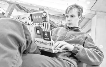  ??  ?? Schonander, a sophomore at George Washington University double-majoring in internatio­nal affairs and economics, settles in to wait for his next class in a lounge on campus after breakfast.