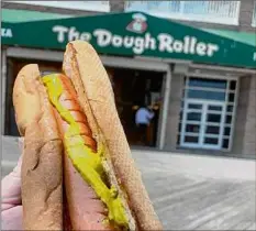  ?? Jessica Kelly / For the Times Union ?? With the Atlantic Ocean as your backdrop, at top, a hot dog from The Dough Roller is the perfect accompanym­ent.