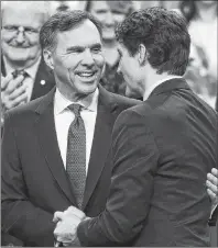  ?? CP PHOTO ?? Finance Minister Bill Morneau is congratula­ted by Prime Minister Justin Trudeau after delivering the federal budget in the House of Commons in Ottawa on Tuesday.