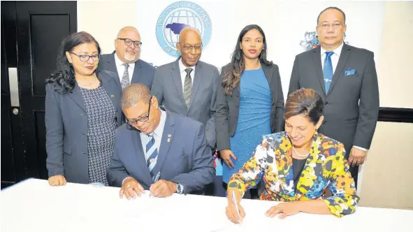  ?? CONTRIBUTE­D ?? Signing the formal agreement are: Robert Scott, dean of Consular Corps of Jamaica, and Dr Luz Longsworth, pro-vice-chancellor and principal of The UWI Open Campus. Sharing in the moment are (from left): Indera Persaud, honorary consul for Guyana; Peter Goldson, honorary consul general for Sweden; Winston Bayley, honorary consul for Barbados; Anneisha Welsh, manager, Business Developmen­t Unit, The UWI Open Campus; and Ambassador Dr Richard Bernal, pro-vice-chancellor for Global Affairs, The UWI.