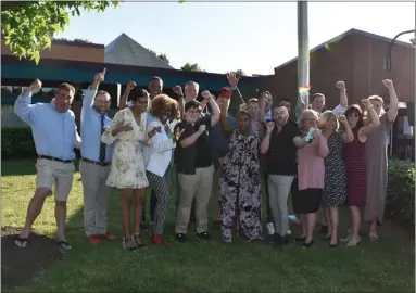  ?? PHOTO COURTESY OF NORTH PENN SCHOOL DISTRICT ?? North Penn School Board members and district and community officials pose below a rainbow Pride flag on a flagpole in front of the district’s Educationa­l Services Center on Thursday.