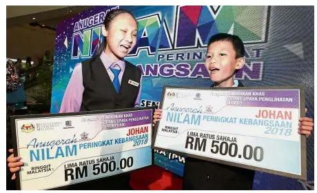  ??  ?? Reading is rewarding: Saw (left) with Kong and their prizes after the awards ceremony in PWTC.