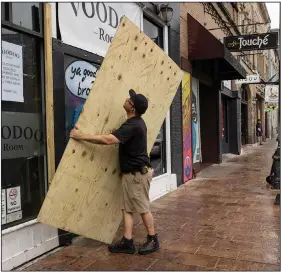  ?? (AP/Austin American-Statesman/Jay Janner) ?? A man boards up the Voodoo Room on East Sixth Street in Austin on Friday after Texas Gov. Greg Abbott ordered bars in Texas to close because of the coronaviru­s.