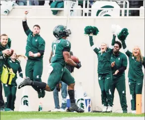  ?? Junfu Han / TNS ?? Michigan State running back Kenneth Walker III runs 27 yards for a touchdown during the second quarter, the first of Walker’s five touchdowns against Michigan in East Lansing, Michigan, on Saturday. Michigan State won, 37-33.