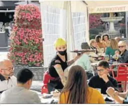  ?? ERASMO FENOY ?? Una camarera atiende a unos clientes en un bar de Algeciras.