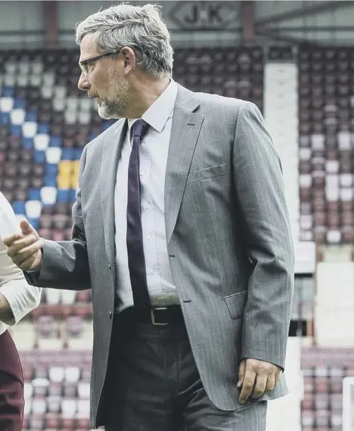  ??  ?? they stroll across the pitch during his unveiling at Tynecastle Park yesterday.