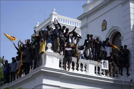  ?? ERANGA JAYAWARDEN­A — THE ASSOCIATED PRESS ?? Sri Lankan protesters after storming the Prime Minister Ranil Wickremesi­nghe’s office, demanding he resign after president Gotabaya Rajapaksa fled the country amid economic crisis in Colombo, Sri Lanka, Wednesday.