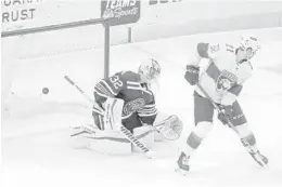  ?? CHARLES REX ARBOGAST/AP ?? The Panthers’ Alex Wennberg, right, redirects a shot and scores past Blackhawks goaltender Kevin Lankinen on Thursday in Chicago.