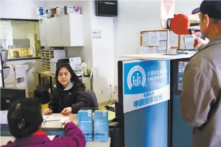  ?? Michael Short / Special to The Chronicle ?? Nancy Chen of the Asian Health Services offices in Oakland (left) helps customer Zi Yu get enrolled for medical coverage.