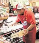  ?? Dylan Aguilar / Houston Chronicle ?? Mark Dolormente stocks cheese at a Kroger.