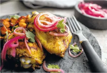  ?? ANDREW SCRIVANI/THE NEW YORK TIMES ?? In this recipe, chicken, bell peppers and sweet potatoes are roasted together on a sheet pan, then sparked with pickled onions.