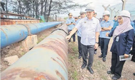  ?? — Bernama photo ?? Fadillah (front, left) visiting the pipe replacemen­t project at the Pulau Enoe main water distributi­on station.