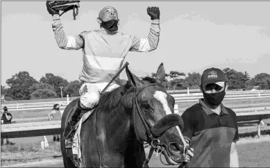  ?? JOE LABOZZETTA/EQUI-PHOTO ?? Mike Smith celebrates after winning last Saturday’s Haskell Invitation­al aboard Authentic.