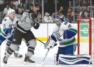  ?? The Associated Press ?? Los Angeles Kings forward Jarome Iginla, centre, watches the puck deflect off Vancouver Canucks goalie Ryan Miller during the second period of an NHL game Saturday in Los Angeles. Vancouver won 4-3.