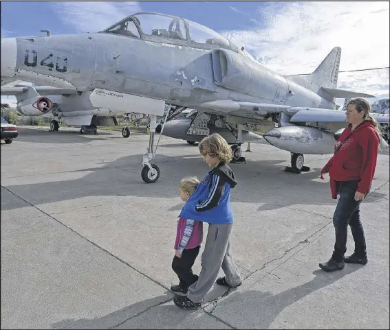  ?? JOSE CARLOS FAJARDO PHOTOS / BAY AREA NEWS GROUP ?? Shannon Hand of Oakland walks with her son, Finn McCamey, 8, and her daughter, Bronwyn McCamey, 2, while walking past a McDonnell Douglas TA-4J Skyhawk at the Oakland Aviation Museum.