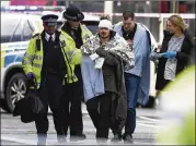  ?? CARL COURT / GETTY IMAGES ?? A wounded man is escorted from the scene of the London attack Wednesday after being treated by emergency services personnel.