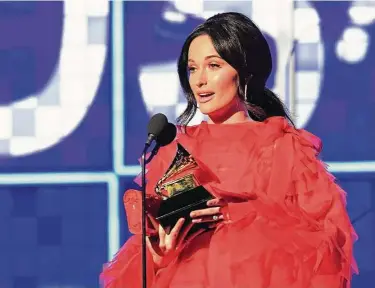  ?? Robyn Beck / AFP/Getty Images ?? Kacey Musgraves accepts the award for Album of the Year for “Golden Hour,” her fourth win of the night.