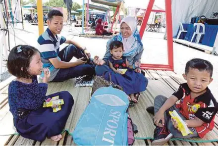  ?? PIC BY ASWADI ALIAS ?? Nurul Atiqah Mohd Sapri and her family relaxing at Media Prima Bhd’s GegaRia Fest in Putrajaya yesterday.