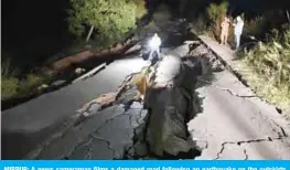  ?? — AFP ?? MIRPUR: A news cameraman films a damaged road following an earthquake on the outskirts of Mirpur.