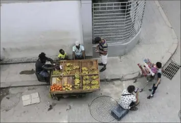  ?? Ariel Ley/Associated Press photos ?? A vendor sells his produce from a cart last week in Havana. Without a functionin­g market economy, Cuban agricultur­e has long measured itself by socialist production goals that it has rarely been able to meet.