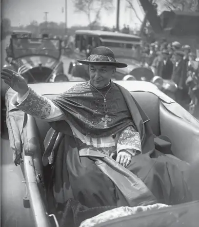  ?? CHICAGO TRIBUNE HISTORICAL PHOTOS ?? Cardinal Mundelein raises his right hand to bestow his blessings upon the crowd on May 11, 1924, during a parade in his honor following his return home from Rome after being appointed Cardinal. According to the Tribune,“people lined the course of the Cardinal from his train to his church solidly for fifteen miles.”