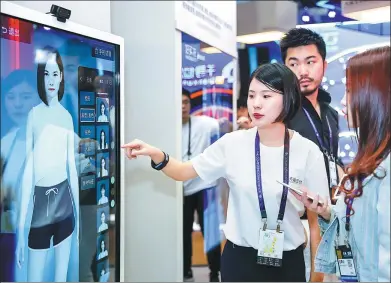  ??  ?? An Alibaba employee introduces a virtual mirror on Wednesday during the company’s annual computing conference in Hangzhou, capital of Zhejiang province.