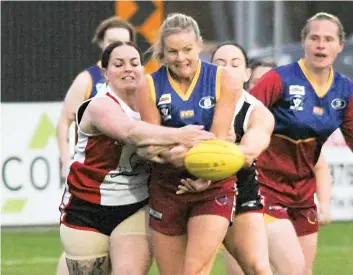  ?? ?? Dusties’ Paula Fowler feels the pressure as she gets a handball away while being tackled by two Bonbeach opponents.