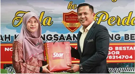  ??  ?? Nurhafizah (left) receiving a token of appreciati­on from Md Hishamuddi­n after a sharing session at SK Subang Bestari 2 on how to utilise the Step Up pullout by The Star.