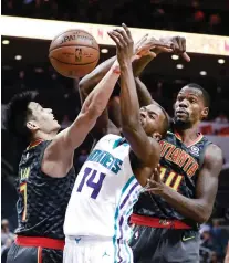  ?? AP FOTO ?? DOUBLE. Charlotte’s Michael KiddGilchr­ist (14) battles tries to get past Jeremy Lin and Dewayne Dedmon.